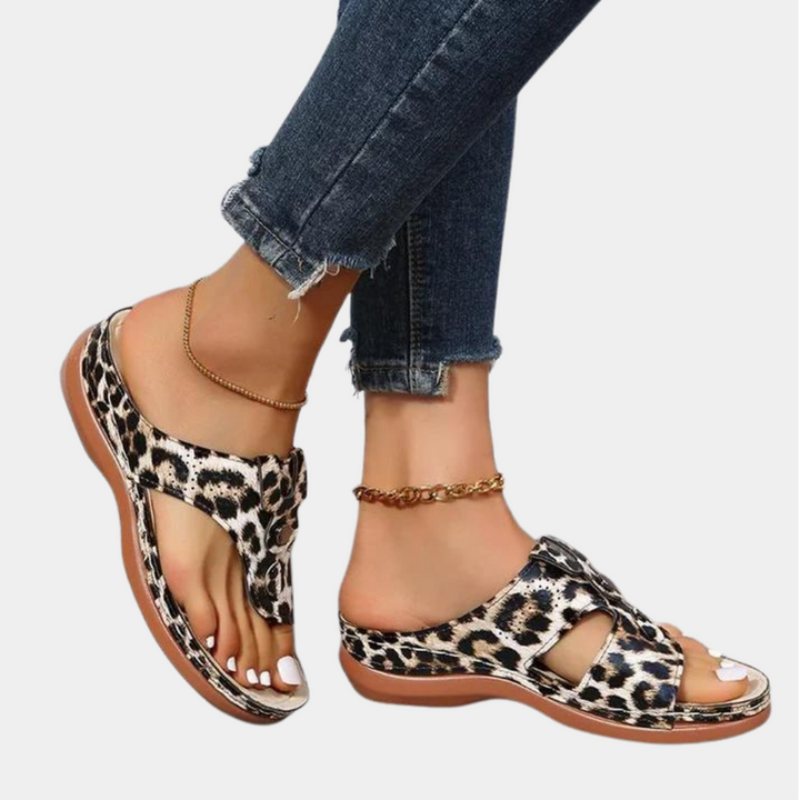Leopardprint sandalen met open teen en lage hak, gedragen met enkelbandjes en gescheurde jeans. Trendy damesmode, comfortabele zomerschoenen.