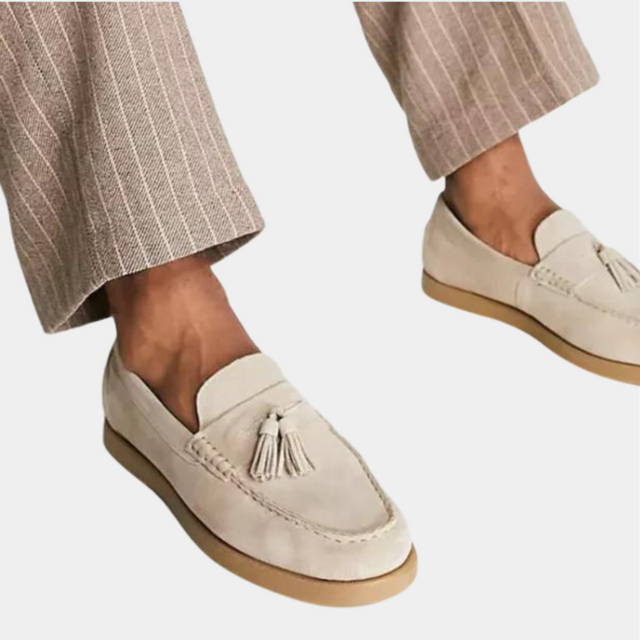 Beige suède loafers met kwastjes, gedragen met gestreepte broek. Stijlvolle herenschoenen, casual en elegant, perfect voor modieuze outfits.