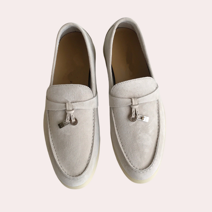 Witte suède loafers met metalen details, stijlvolle instappers voor dames. Comfortabele en modieuze schoenen, perfect voor casual en zakelijke outfits.