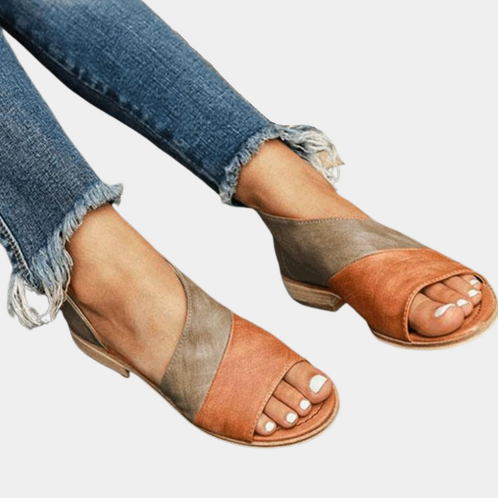 Bruin-oranje leren sandalen met open teen en lage hak, gedragen met gerafelde jeans. Stijlvolle damesmode, zomerschoeisel.