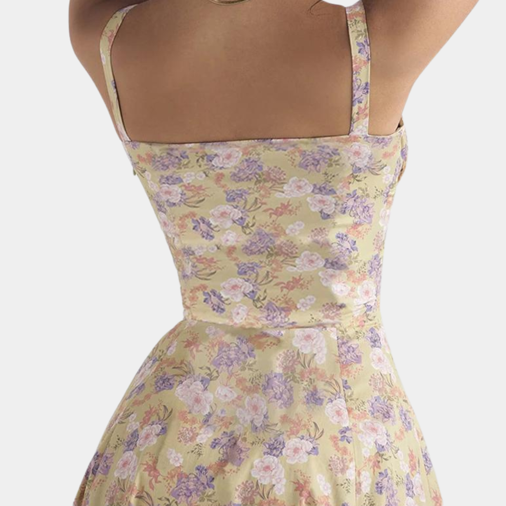 Vrouw in bloemenjurk met pastelkleuren, mouwloos ontwerp, getailleerde pasvorm. Perfect voor zomermode, casual en elegante stijl.