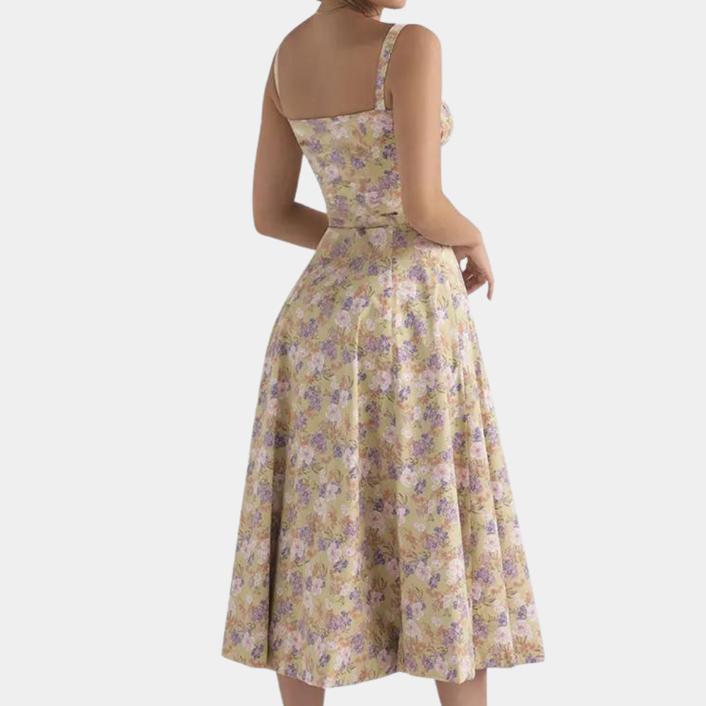 Vrouw in vintage bloemenjurk met gele en paarse bloemen, mouwloos ontwerp, A-lijn rok. Perfect voor zomerse mode en retro stijl.