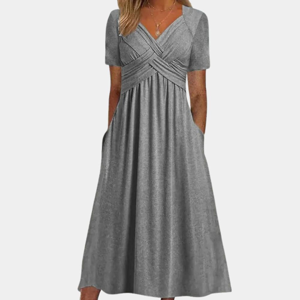 Grijze damesjurk met korte mouwen en V-hals, elegante plooien en zakken. Perfect voor casual en formele gelegenheden. Comfortabele pasvorm.