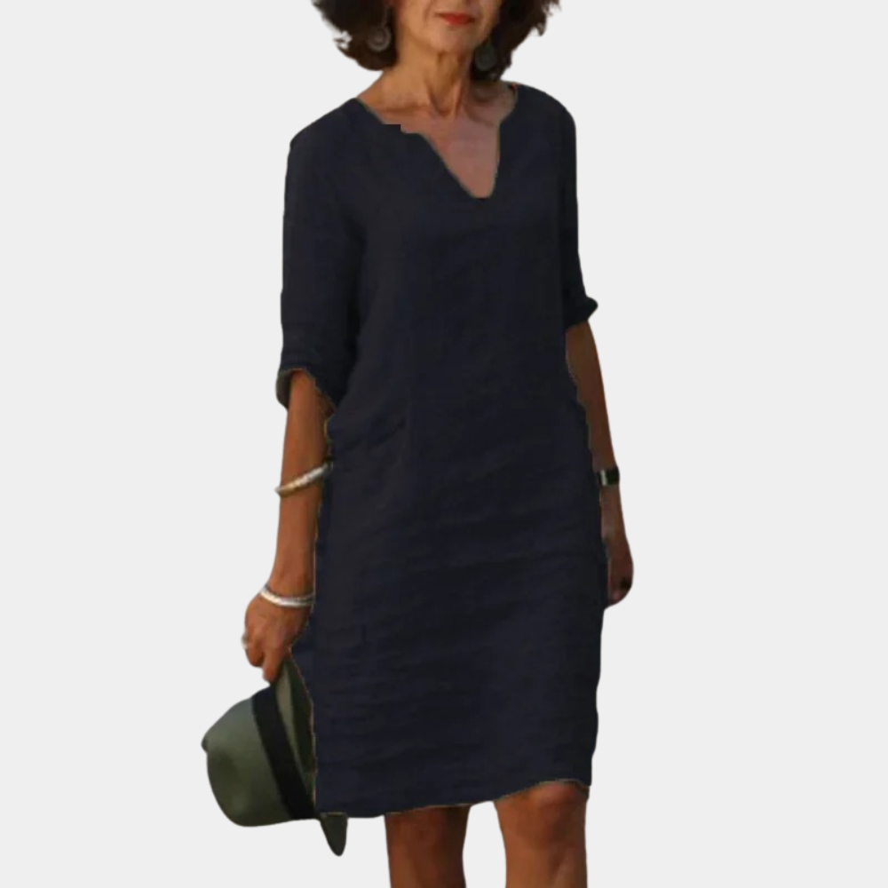 Zwarte linnen jurk met V-hals en driekwart mouwen, gedragen door vrouw. Stijlvolle casual damesmode, perfect voor zomer en lente.