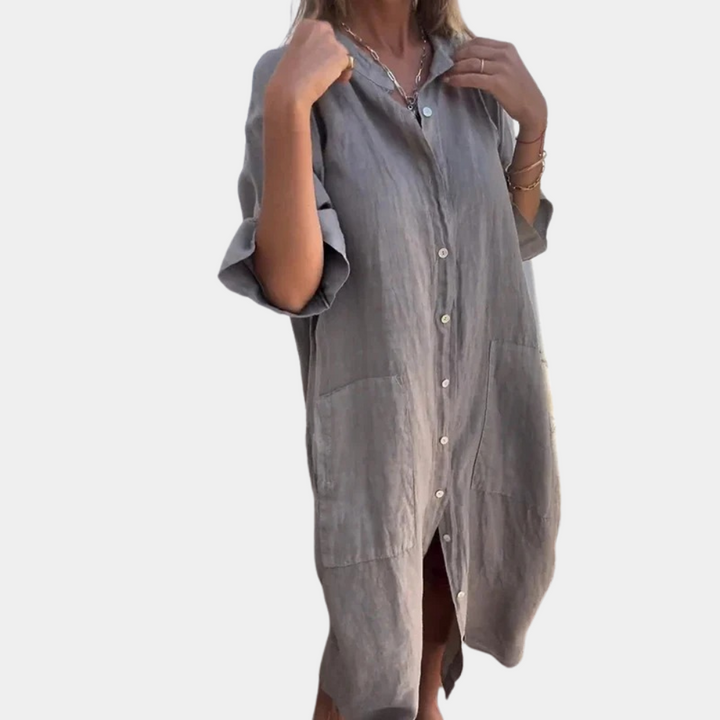 Grijze linnen damesjurk met knoopsluiting, driekwart mouwen en zakken. Stijlvolle casual outfit voor lente en zomer.