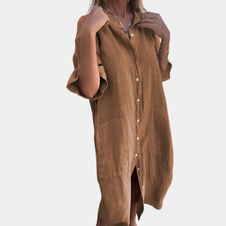 Vrouw in khaki linnen overhemdjurk met knoopsluiting en opgerolde mouwen. Stijlvolle casual damesmode, perfect voor lente en zomer.