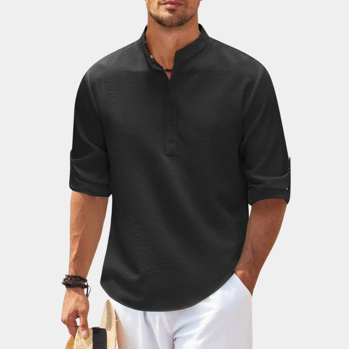 Zwarte herenlinnen overhemd met opgerolde mouwen, knoopsluiting en opstaande kraag. Stijlvolle casual look voor zomer- en strandmode.