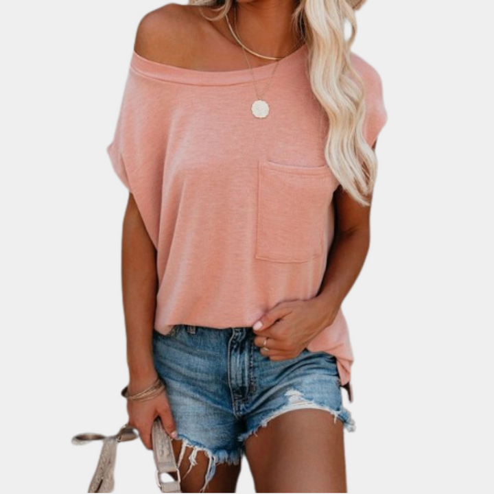 Vrouw in roze off-shoulder top met borstzak en denim shorts, zomermode, casual outfit, trendy kledingstijl, blonde golvende haren.