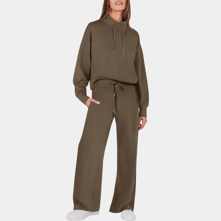 Vrouw in bruine joggingpak met capuchon en wijde broek, casual mode, comfortabele dameskleding, trendy loungewear, witte sneakers.