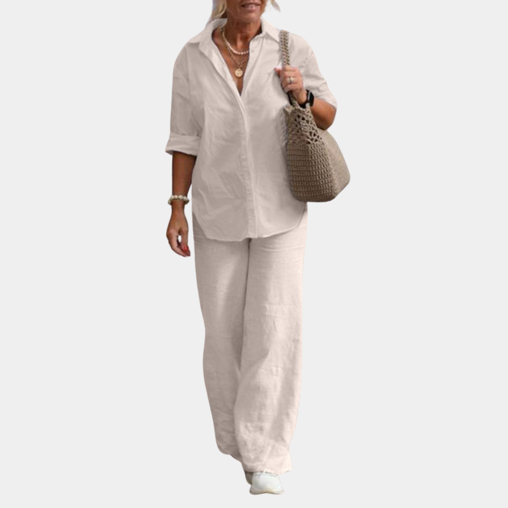 Vrouw in casual outfit met witte blouse, wijde linnen broek en beige tas. Stijlvolle damesmode, comfortabele kleding, zomerse look.