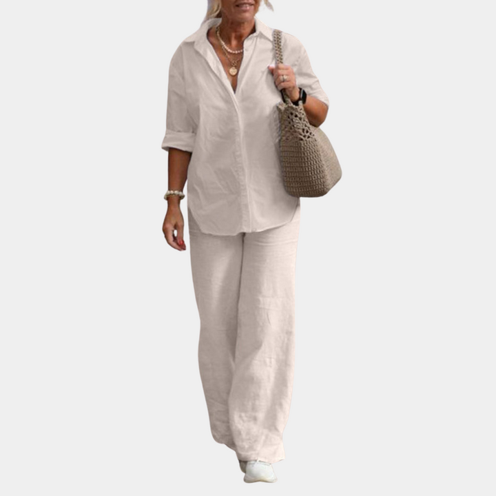 Vrouw in casual outfit met witte blouse, wijde linnen broek en beige tas. Stijlvolle damesmode, comfortabele kleding, zomerse look.