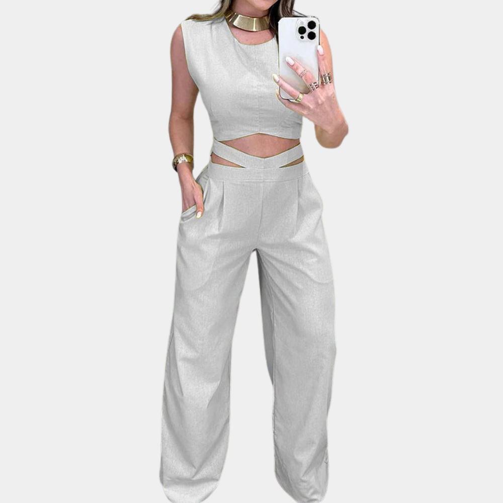 Grijze dames jumpsuit met cut-out details, mouwloos ontwerp en wijde pijpen. Perfect voor modieuze casual of avondkleding.