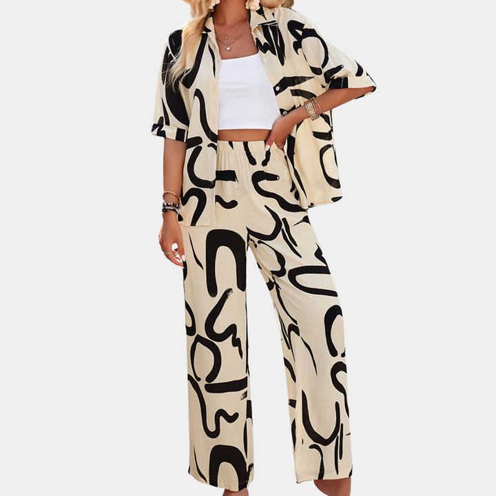 Dames zomeroutfit met abstracte print, bestaande uit een beige blouse en broek. Modieuze casual kleding, perfect voor warme dagen.