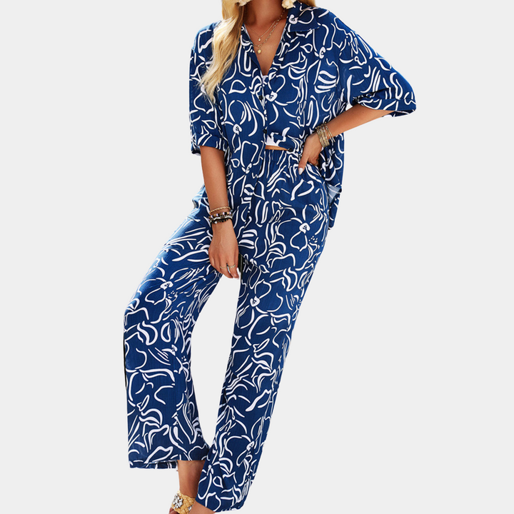 Blauwe dames jumpsuit met abstract patroon, korte mouwen en wijde pijpen. Modieuze zomeroutfit, casual stijl, comfortabele pasvorm.