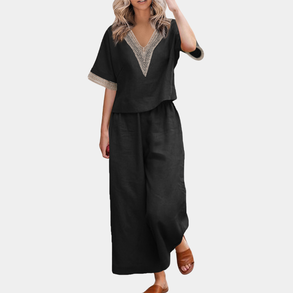 Zwarte linnen damesoutfit met V-hals en kanten details, bestaande uit een losse top en wijde broek. Perfect voor casual zomerlooks.