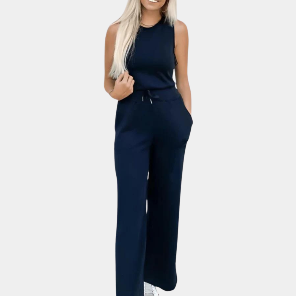 Vrouw in marineblauwe jumpsuit met wijde pijpen en mouwloos ontwerp, casual en stijlvol, perfect voor dagelijks gebruik of zomerse gelegenheden.