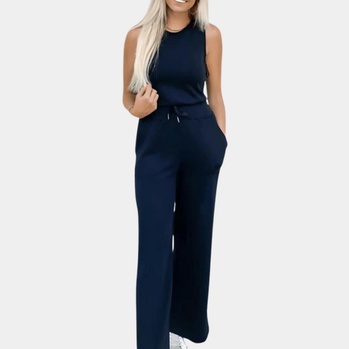Vrouw in marineblauwe jumpsuit met wijde pijpen en mouwloos ontwerp, casual en stijlvol, perfect voor dagelijks gebruik of zomerse gelegenheden.