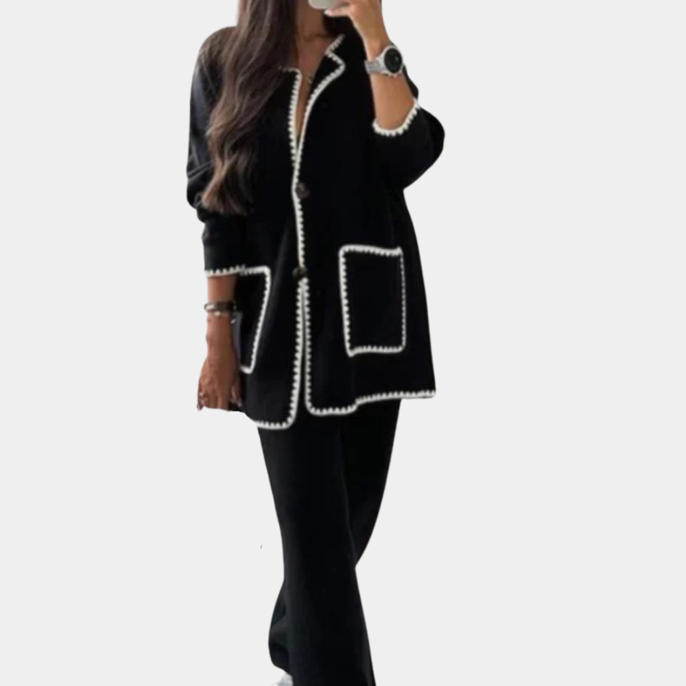 Zwarte damesjas met witte bies, lange mouwen en zakken. Stijlvolle herfstmode, perfect voor casual en zakelijke outfits.