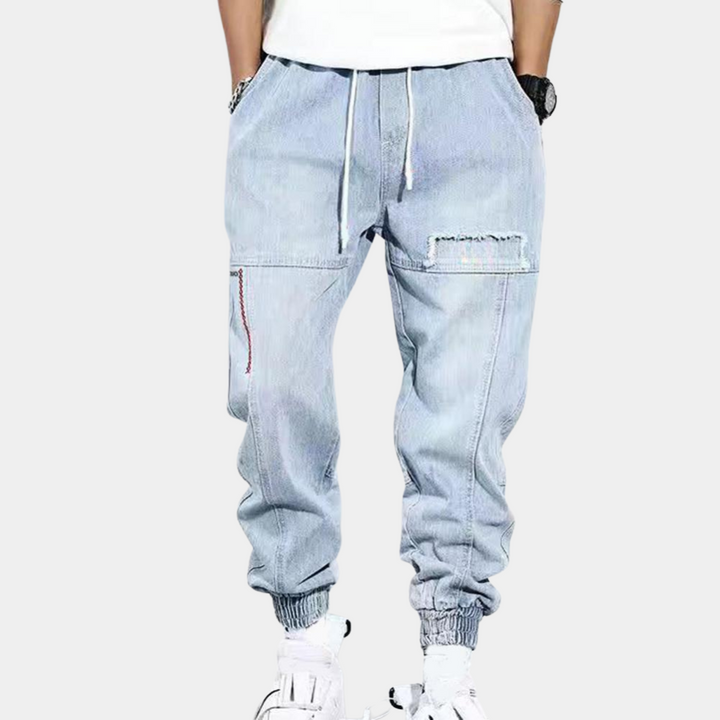 Lichtblauwe heren jogger jeans met elastische tailleband, trekkoord en zakken. Modieuze streetwear broek voor casual stijl.