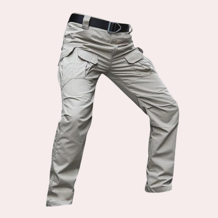 Khaki tactische broek met meerdere zakken en riem, ideaal voor outdoor activiteiten. Duurzaam materiaal, comfortabele pasvorm. Geschikt voor heren.