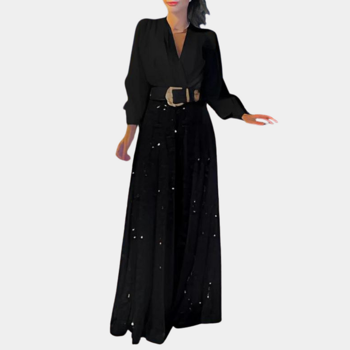 Zwarte maxi-jurk met lange mouwen en diepe V-hals, voorzien van een brede riem en subtiele pailletten. Perfect voor avondkleding en feestelijke gelegenheden.