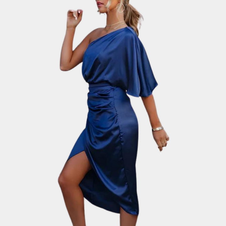 Vrouw in elegante, asymmetrische, blauwe satijnen jurk met één schouder, hoge split en ruches. Perfect voor avondkleding en speciale gelegenheden.