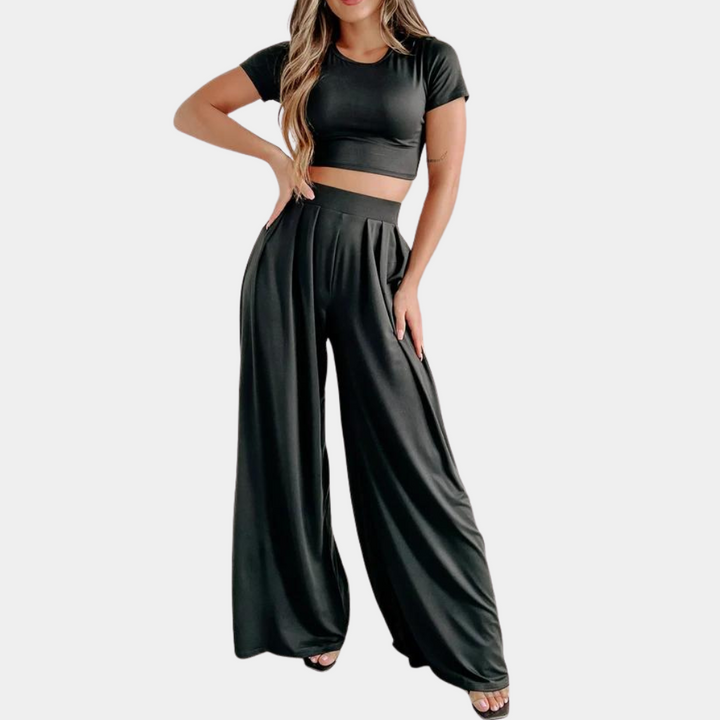 Zwarte dames co-ord set met crop top en wijde broek, modieuze tweedelige outfit, comfortabele pasvorm, ideaal voor casual en trendy gelegenheden.