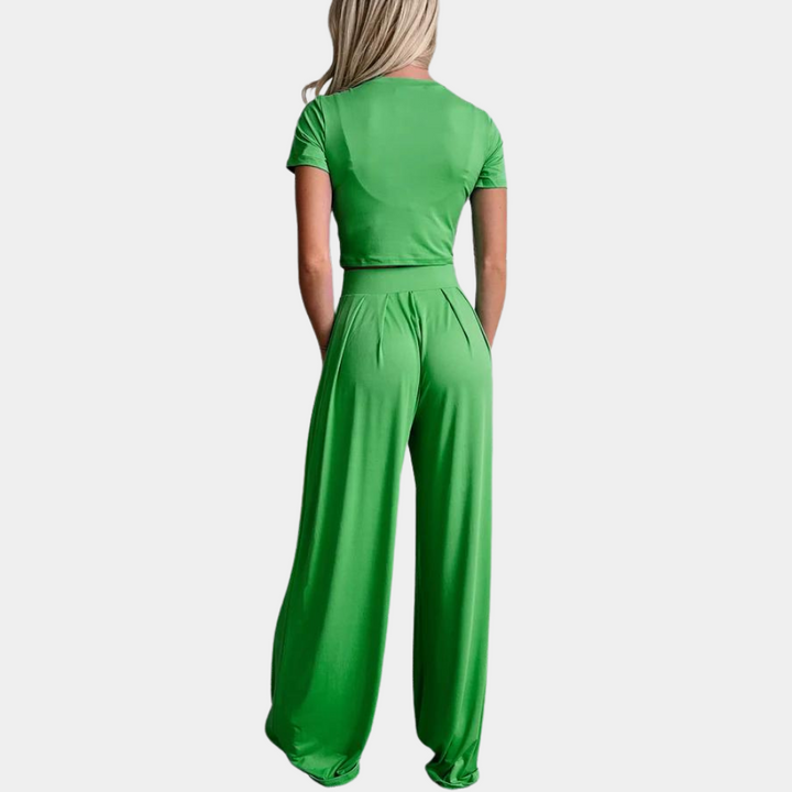 Groen damespak met korte mouwen en wijde broek, achterkant. Modieuze outfit, comfortabele pasvorm, trendy kleding voor dames.