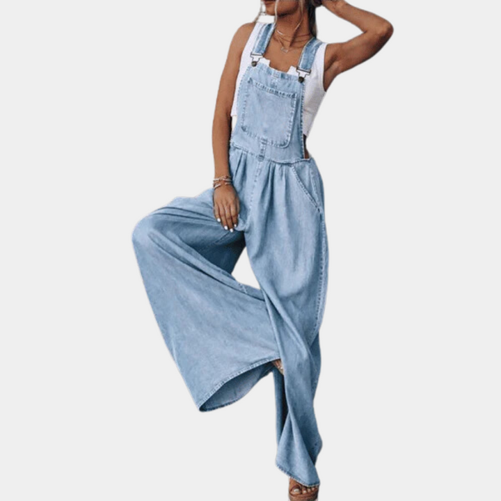 Vrouw in lichtblauwe denim tuinbroek met wijde pijpen, witte top. Modieuze dameskleding, casual stijl, trendy outfit voor dagelijks gebruik.