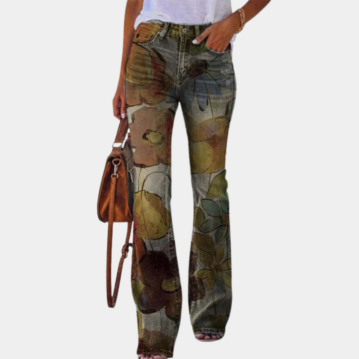 Vrouw draagt wijde bloemenbroek met handtas en wit T-shirt. Trendy damesmode, casual outfit, bohemian stijl, kleurrijke print.