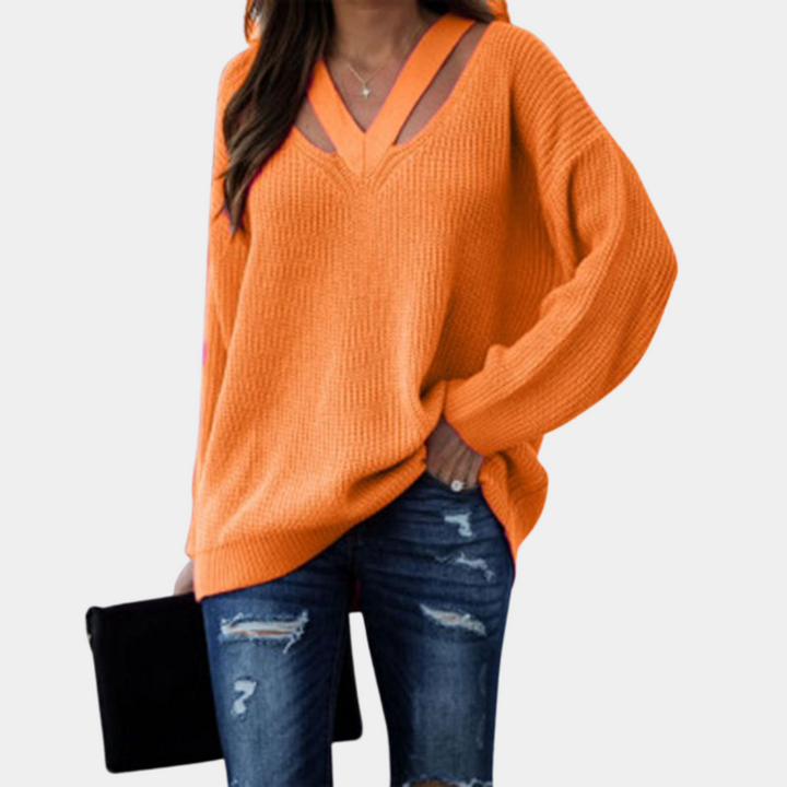 Oranje damestrui met V-hals en lange mouwen, gecombineerd met gescheurde jeans. Trendy herfstmode, comfortabele casual outfit.