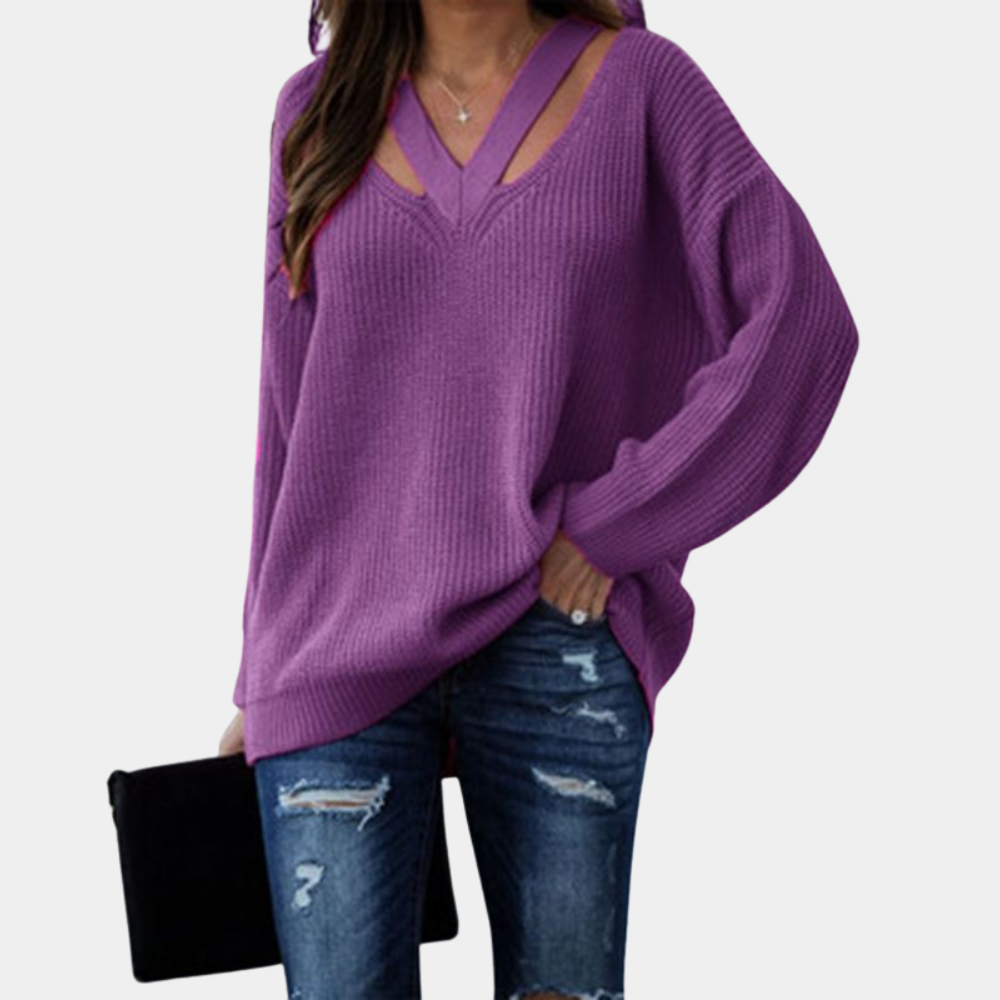 Paarse trui met V-hals en uitgesneden details, gedragen met gescheurde jeans en zwarte clutch. Modieuze dameskleding, casual stijl.