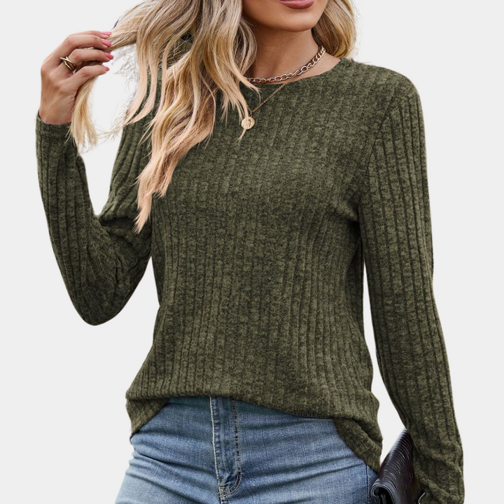Vrouw draagt een olijfgroene, geribbelde trui met lange mouwen en blauwe jeans. Modieuze herfstkleding, casual stijl, comfortabele pasvorm.