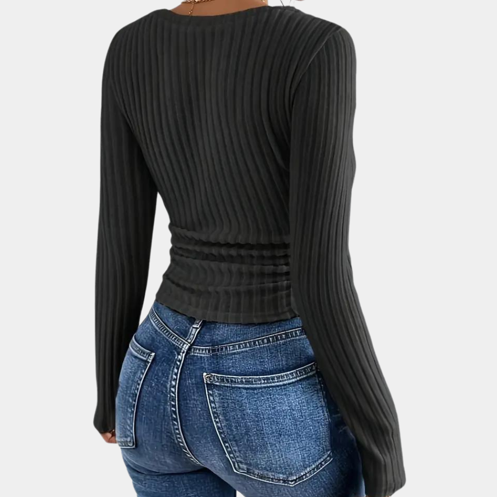 Zwarte geribbelde damestrui met lange mouwen, gecombineerd met blauwe jeans. Modieuze casual outfit, perfect voor herfst- en winterseizoenen.