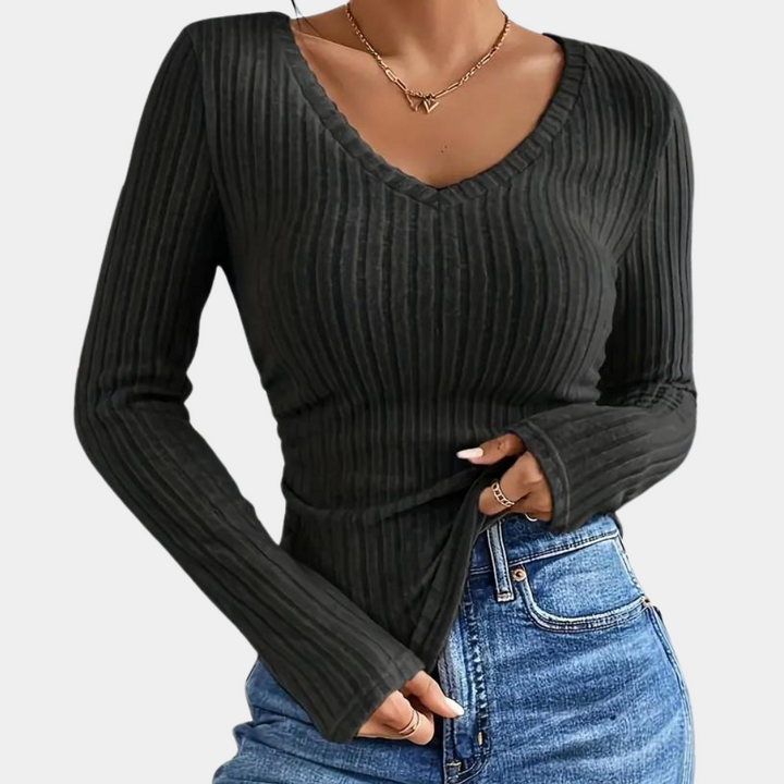 Zwarte geribbelde V-hals trui voor dames, lange mouwen, gecombineerd met blauwe jeans. Modieuze casual outfit, perfect voor herfst en winter.