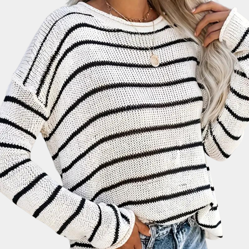 Witte gebreide trui met zwarte strepen, lange mouwen en ronde hals, gedragen door model. Modieuze dameskleding, casual stijl, herfstmode.