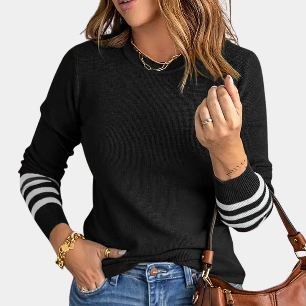 Zwarte damestrui met witte strepen op de mouwen, gedragen door vrouw met gouden sieraden en bruine handtas. Casual mode, herfstkleding.