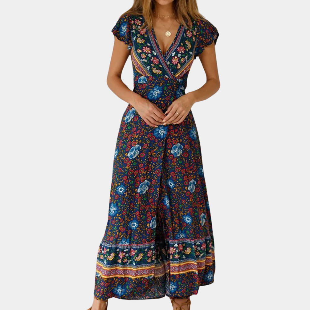 Vrouw in donkerblauwe maxi-jurk met bloemenprint en korte mouwen, bohemian stijl, ideaal voor zomer en casual gelegenheden.