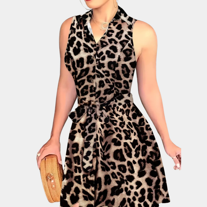 Vrouw in mouwloze luipaardprint jurk met strikceintuur, houdt een rieten clutch. Modieuze zomeroutfit, trendy dierenprint kleding.