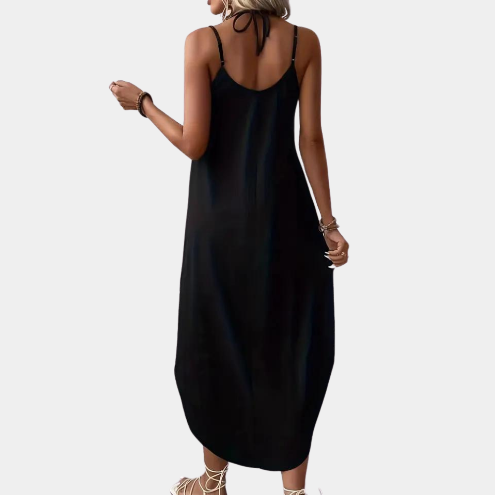 Zwarte maxi-jurk met spaghettibandjes, gedragen door vrouw. Perfect voor zomer, casual en strand. Comfortabele en stijlvolle damesmode.