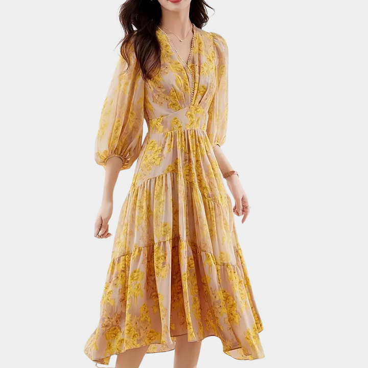 Vrouw in elegante gele bloemenjurk met pofmouwen en V-hals, perfect voor zomermode. Stijlvolle dameskleding, trendy en modieus ontwerp.