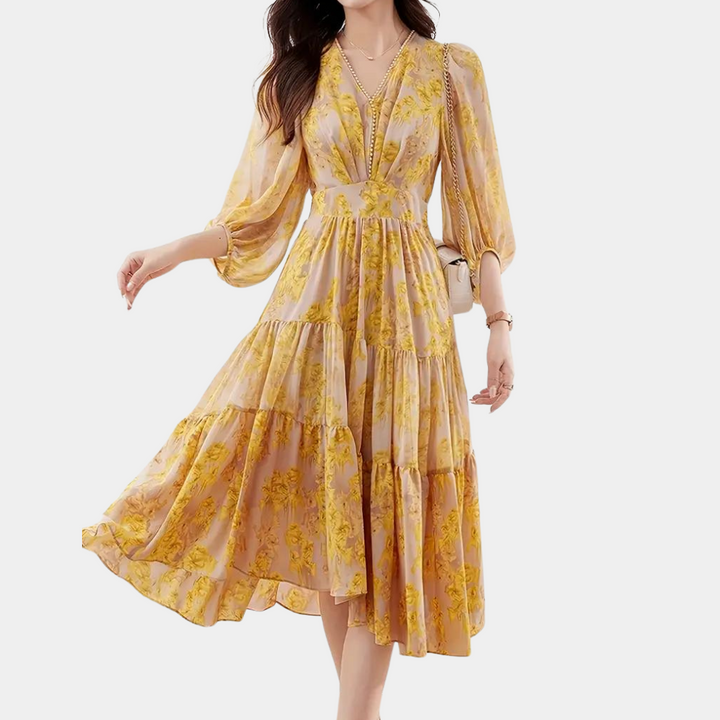 Vrouw in gele bloemenjurk met lange mouwen en V-hals, elegante zomermode, casual chique stijl, perfect voor lente en zomer.