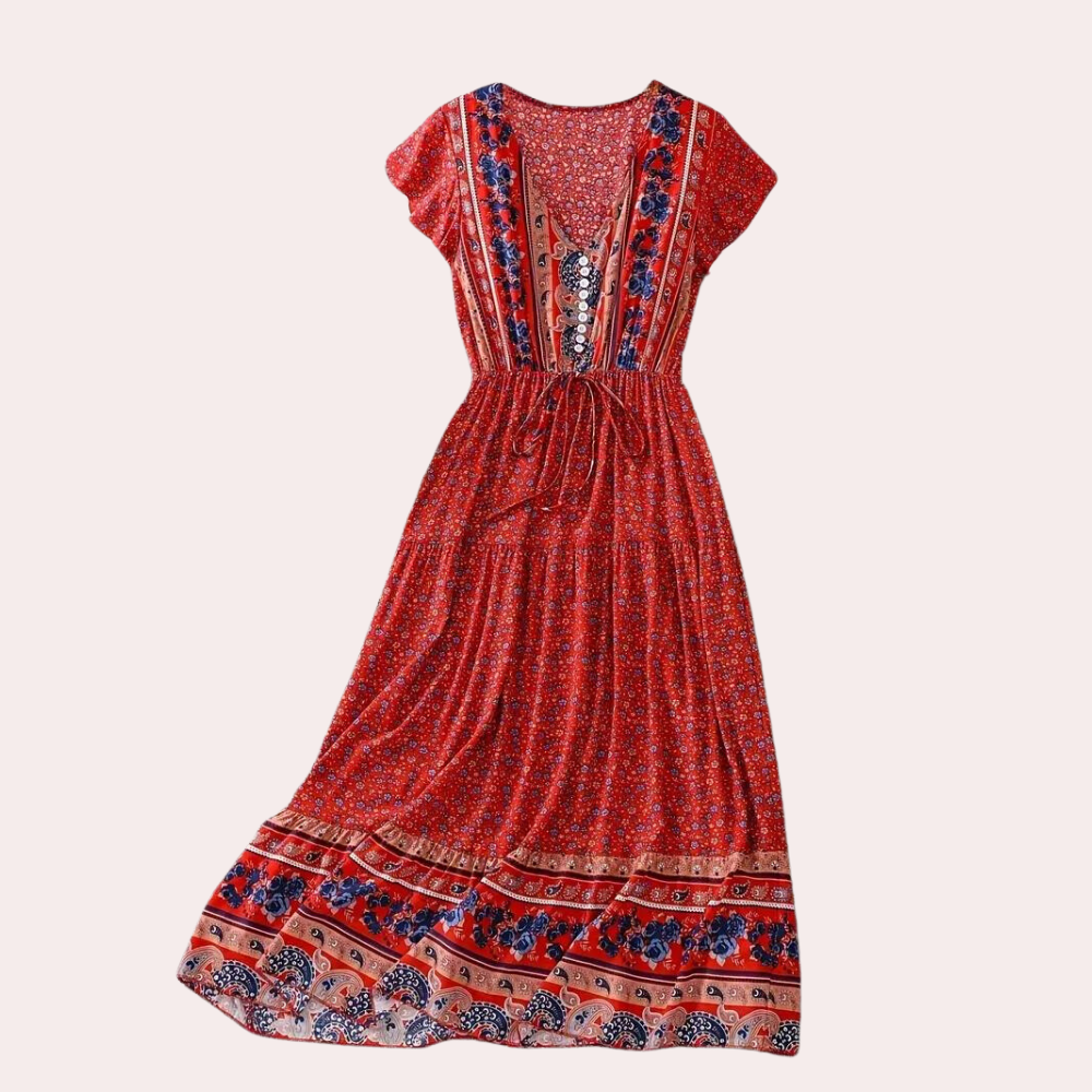 Rode bohemian maxi-jurk met bloemenprint, korte mouwen en taillekoord. Perfect voor zomerse dagen en festivals. Vrouwelijke boho-stijl.