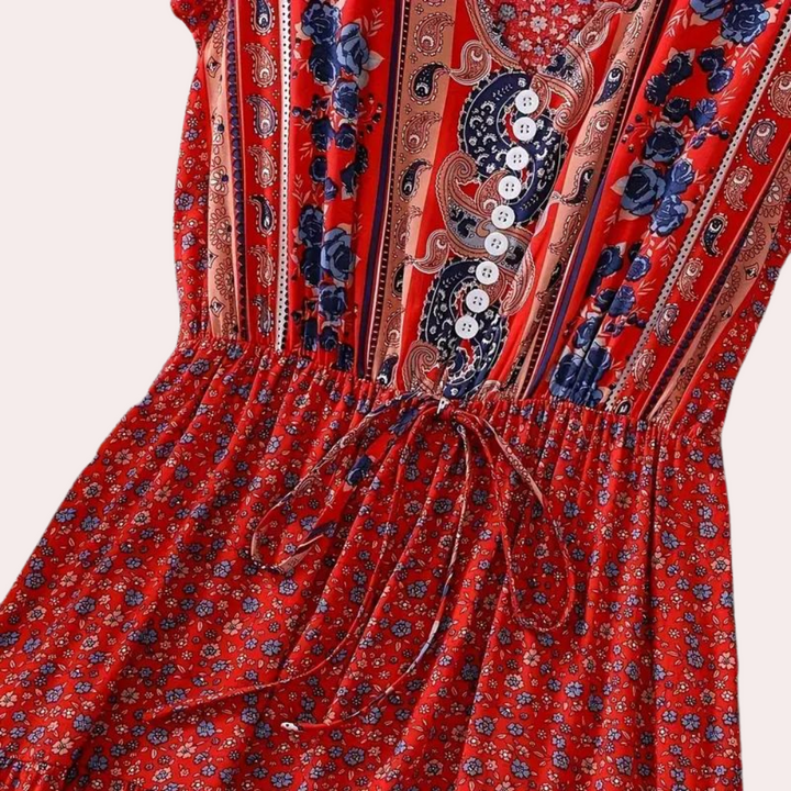 Rode bohemian jurk met bloemen- en paisleyprint, knoopsluiting en taillekoord. Perfect voor zomerse festivals en casual mode.