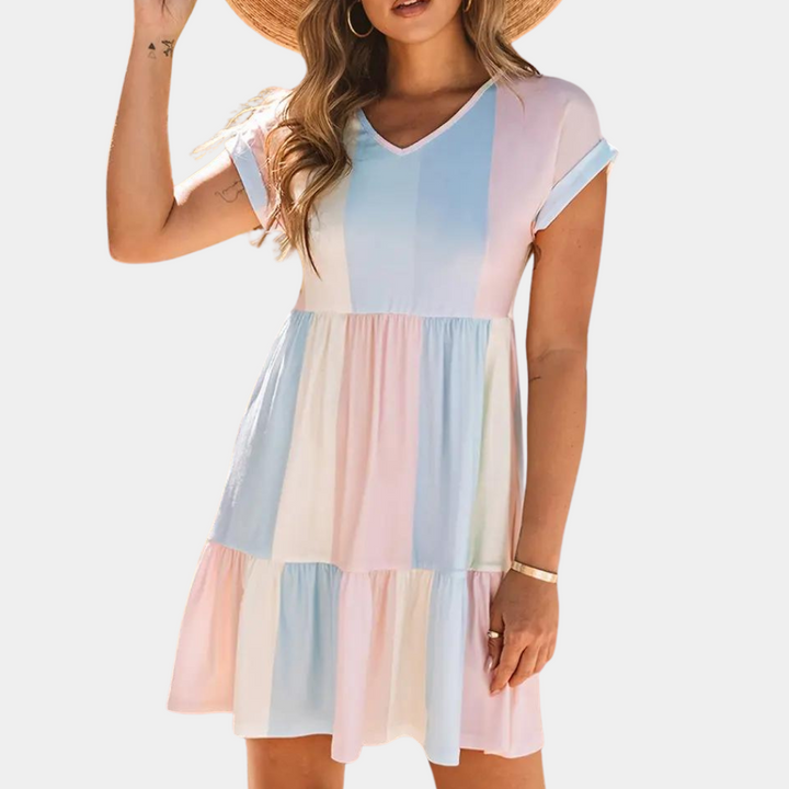 Vrouw in zomerse jurk met pastelkleurige strepen, korte mouwen en V-hals. Perfect voor casual zomeroutfits. Trendy damesmode.