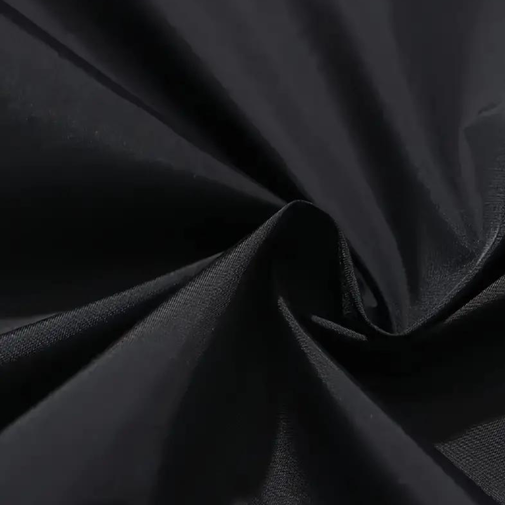 Zwarte katoenen stof close-up, gladde textuur, geschikt voor kleding en interieur, hoogwaardige textielmaterialen, duurzaam en veelzijdig.