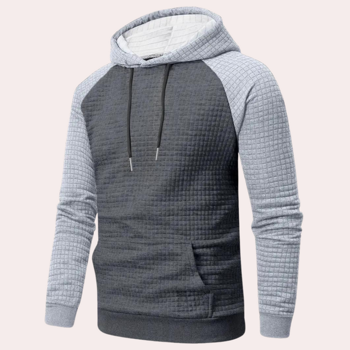 Grijze gewatteerde hoodie met capuchon en trekkoorden, lange mouwen en buidelzak. Comfortabele herentrui, ideaal voor casual en sportieve looks.