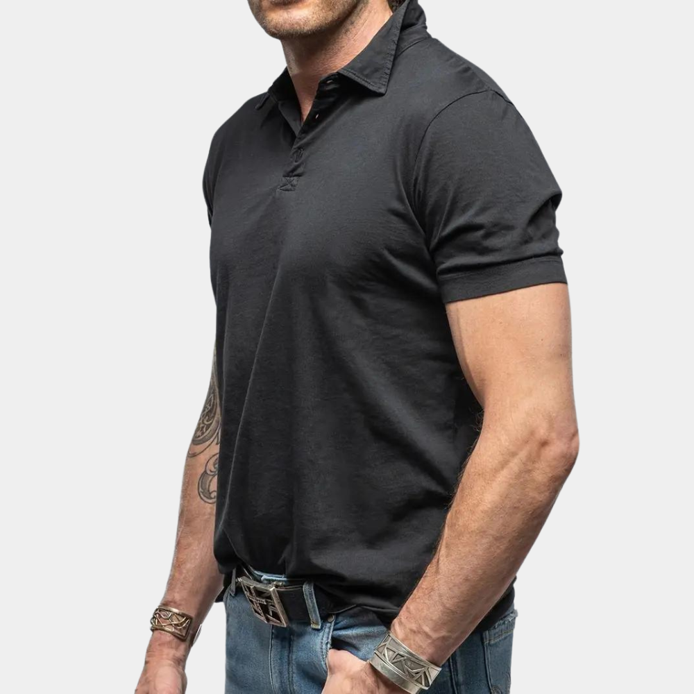 Zwarte polo heren, korte mouwen, casual stijl, gedragen met blauwe jeans en zilveren armbanden. Perfect voor modieuze, alledaagse outfits.