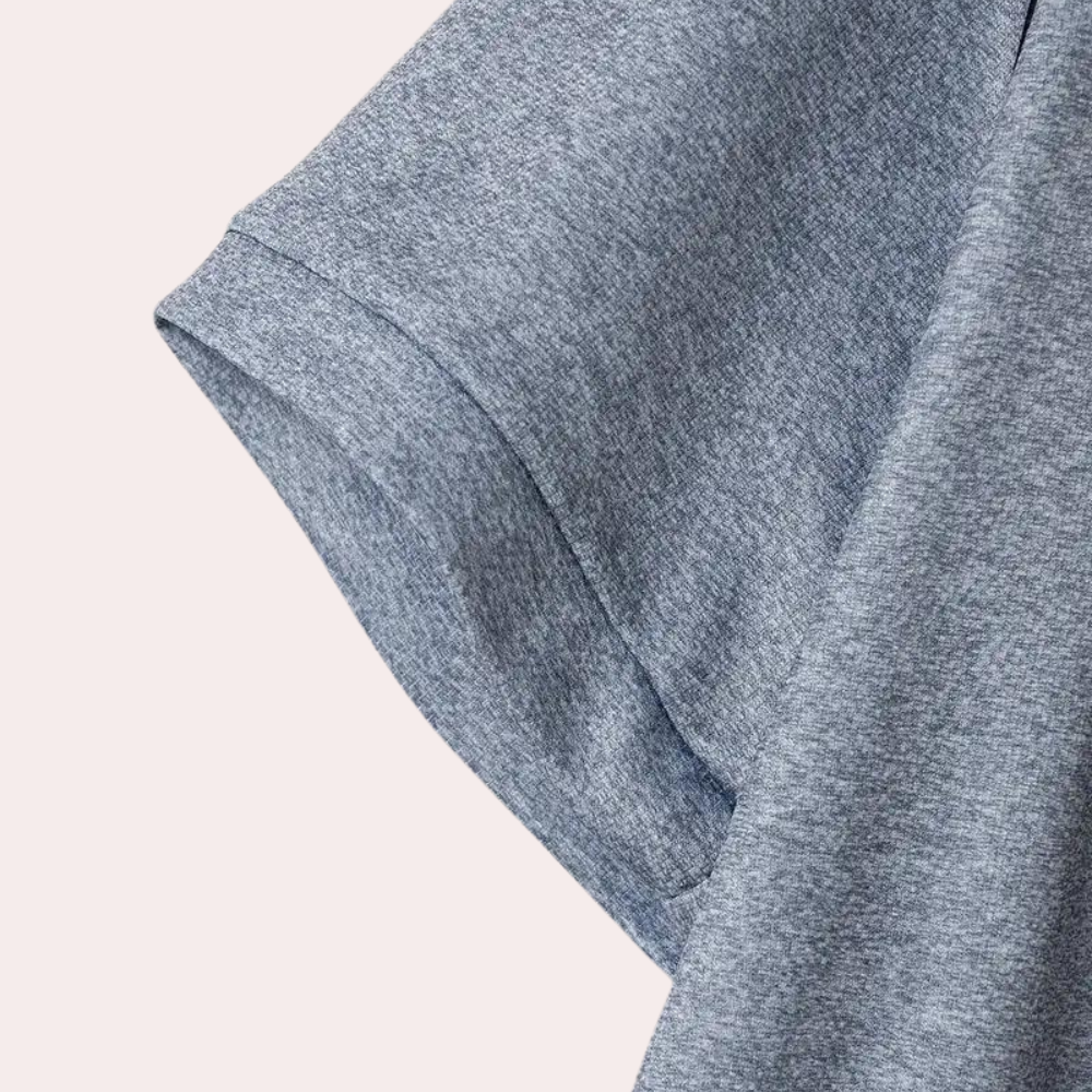 Grijze katoenen T-shirt mouw, close-up. Zachte stof, casual kleding, comfortabele pasvorm. Perfect voor dagelijks gebruik en minimalistische stijl.