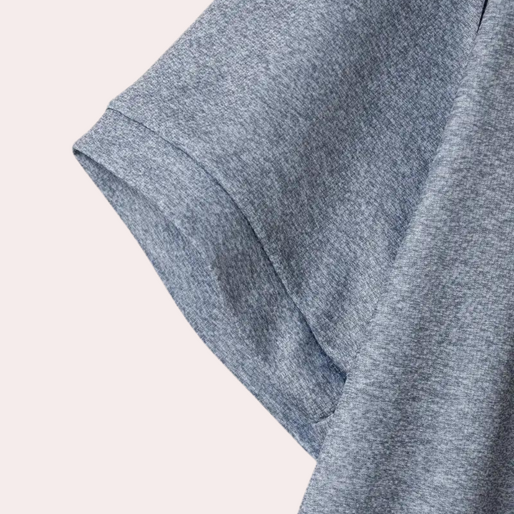 Grijze katoenen T-shirt mouw, close-up. Zachte stof, casual kleding, comfortabele pasvorm. Perfect voor dagelijks gebruik en minimalistische stijl.